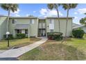 Exterior close up of condo units, sidewalk, well maintained lawn and shrubbery, and some palm trees at 543 Fairways Dr # B, Ocala, FL 34472