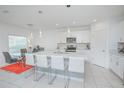 Bright, modern kitchen with white cabinetry, stainless steel appliances, a large island, and eat-in dining area at 5709 Sagunto Dr, Davenport, FL 33897