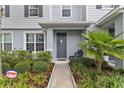 Charming entryway with a walkway, palm tree, and lush landscaping at 6067 Blue Lily Way, Winter Garden, FL 34787