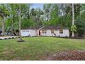 Single-story home featuring a green lawn, landscaping, and a vibrant red front door at 703 Sailfish Rd, Winter Springs, FL 32708