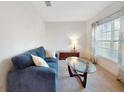 Cozy living room featuring a comfortable blue sofa and a large window with floral curtains at 734 Andalusia Loop, Davenport, FL 33837