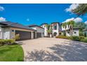 Beautiful home featuring a circular driveway, lush landscaping, and an attached three-car garage at 8336 Boyla Ct, Windermere, FL 34786
