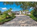 Beautiful home featuring a circular driveway, lush landscaping, and an attached three-car garage at 8336 Boyla Ct, Windermere, FL 34786