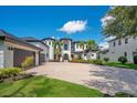 Beautiful home featuring a circular driveway, lush landscaping, and an attached three-car garage at 8336 Boyla Ct, Windermere, FL 34786