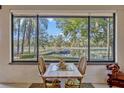Dining area with a view of the lake and a small table with seating for two at 9318 Lake Hickory Nut Dr, Winter Garden, FL 34787
