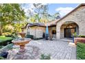 Charming brick home featuring a beautifully paved entrance, inviting fountain, and manicured landscaping at 9318 Lake Hickory Nut Dr, Winter Garden, FL 34787