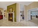 Elegant living room with a marble fireplace, open layout, and tile flooring leading to a bedroom and second living area at 9318 Lake Hickory Nut Dr, Winter Garden, FL 34787
