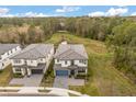 Aerial view of home featuring a tiled roof, professional landscaping and large green space at 1242 Butterfly Orchid Rd, Davenport, FL 33837