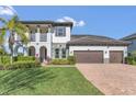 Beautiful two-story home with a brick-paved driveway, a two-car garage, and a meticulously maintained lawn at 16629 Broadwater Ave, Winter Garden, FL 34787