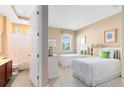 Bright bedroom featuring twin beds, a window, and an adjacent bathroom with shower and tub at 1720 Bridgets Ct, Kissimmee, FL 34744