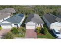 Aerial view of the property showcasing a well-maintained home with brick driveway and green landscaping at 17398 Blazing Star Cir, Clermont, FL 34714