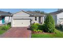 Charming single Gathering home with a paver driveway, two car garage, and manicured landscaping at 17398 Blazing Star Cir, Clermont, FL 34714