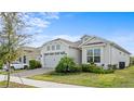 A home with a two-car garage and well-maintained front lawn with beautiful landscaping at 2087 Flora Pass Pl, Kissimmee, FL 34747