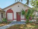 Close-up of home's facade with decorative accents, front door and tropical landscaping at 2200 Pine Needle Trl, Kissimmee, FL 34746