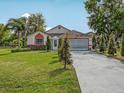 Inviting single-story home with a well-kept lawn and a long driveway at 2200 Pine Needle Trl, Kissimmee, FL 34746