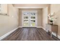 Bright foyer with new wood flooring, stylish console table with decor, and exterior glass paneled doors at 2335 Coldstream Dr, Winter Park, FL 32792