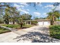 Inviting single-story home showcasing a spacious driveway, a two-car garage, and lush green lawn at 2335 Coldstream Dr, Winter Park, FL 32792