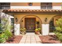 Close-up of the home's entrance featuring arched brickwork, a tiled walkway, and decorative plants at 275 Clearview Rd, Chuluota, FL 32766