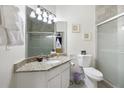 Bright bathroom featuring a granite countertop vanity and glass door shower at 2784 Almaton Loop # 301, Kissimmee, FL 34747