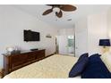 Comfortable main bedroom with a ceiling fan, television, and a doorway to the bathroom at 2784 Almaton Loop # 301, Kissimmee, FL 34747