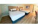 A cozy room featuring two double beds, a nightstand, and modern flooring for a comfortable stay at 3000 Maingate Ln # 227, Kissimmee, FL 34747