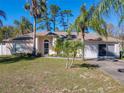 Inviting single-story home with a well-maintained lawn and charming tropical landscaping at 3252 Noah St, Deltona, FL 32738