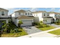 Charming curb view showcases a well-maintained lawn and a paved driveway leading to an attached two-car garage at 3428 Lilac Way, Davenport, FL 33897