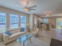Bright living room with large windows, tile floor, and seamless access to the kitchen and dining area at 3593 Brighton Park Cir, Belle Isle, FL 32812