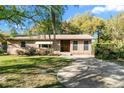Quaint brick house featuring a neatly kept lawn, traditional windows and a front-facing driveway at 46 Smyrna Dr, Debary, FL 32713