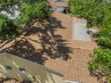 Aerial view of a brown shingle roof partially shaded by trees at 4907 Lindsay Ct, Orlando, FL 32821