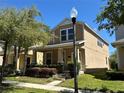 Charming two-story home with a well-manicured lawn and inviting front porch at 5771 Mangrove Cove Ave, Winter Garden, FL 34787