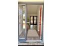 Bright and inviting entryway with a red door, wood floors, and view of the living space with french doors at 5830 Beechmont Blvd, Orlando, FL 32808