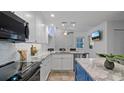 Modern kitchen with white cabinets, stainless steel appliances, and a gray marble countertop island at 610 Chestnut Oak Cir # 114, Altamonte Springs, FL 32701
