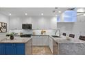 Updated kitchen features stainless steel appliances, a center island with seating, and modern white cabinetry at 610 Chestnut Oak Cir # 114, Altamonte Springs, FL 32701