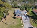 Aerial view of a charming home with lush landscaping, a long driveway, and mature palm trees at 709 S Parsons Ave, Deland, FL 32720