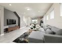 Bright and airy living room with modern furniture, neutral colors and a view into dining area at 7376 Oakmoss Loop, Davenport, FL 33837