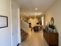 Inviting living room featuring neutral tile floors with entry to large dining room at 7609 Brookhurst Ln, Kissimmee, FL 34747