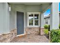 Inviting front porch featuring a brick paver floor, stone accents, and a stylish front door at 937 Avery Meadows Way, Deland, FL 32724