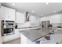 Modern kitchen with stainless steel appliances, white cabinets, and a large center island at 965 Talon Pl, Winter Springs, FL 32708