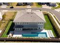 Backyard aerial view features a pool, patio, and manicured lawn enclosed by fencing and neighboring properties at 10032 Brocksport Cir, Gotha, FL 34734