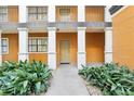 Close up of a condo entrance, showcasing the building's exterior features and tidy landscaping at 12527 Floridays Resort Dr # E-111, Orlando, FL 32821