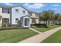 Inviting two-story townhouse featuring manicured lawn and sidewalk leading to the front door at 1325 Seburn Rd, Apopka, FL 32703