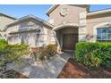 Inviting home exterior with arched entryway, manicured shrubs, and a two-car garage at 1549 Balsam Willow Trl, Orlando, FL 32825