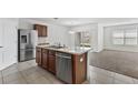 Bright kitchen with stainless steel appliances, tile flooring, and a view of the living area at 16140 Yelloweyed Dr, Clermont, FL 34714