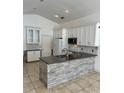 Bright kitchen with white cabinets, granite countertops, stainless steel appliances, and a stone island at 1623 Bridgeview Cir, Orlando, FL 32824