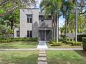 Contemporary home with a manicured lawn, trimmed hedges, and tall palm trees enhancing curb appeal at 1970 Laurel Rd, Winter Park, FL 32789