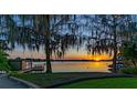 Picturesque backyard with a private dock, beautiful sunset views over the water, and mature trees at 2020 Venetian Way, Winter Park, FL 32789