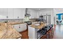 Bright kitchen features granite countertops, stainless appliances, an island with seating, and white cabinets at 2109 E Central Blvd, Orlando, FL 32803