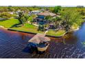 Waterfront home aerial view showing covered boathouse, lush lawn, mature palms, and water frontage at 2112 Shady Ln, Geneva, FL 32732