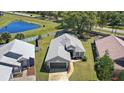 Aerial view of a single-story home with a well-maintained yard and a neighboring pond at 2511 Chatham Cir, Kissimmee, FL 34746